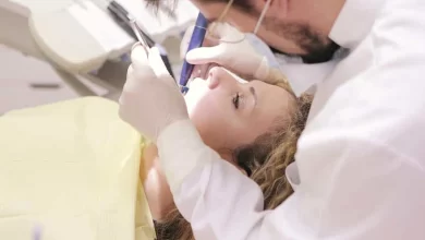 دندان پزشک مرد درحال درست کردن دندان یک خانم